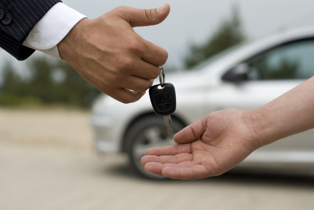 agent handing out car key to customer