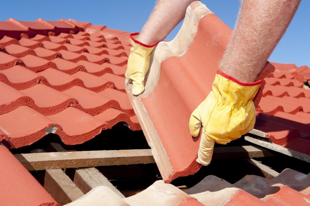 worker rrepairs roof