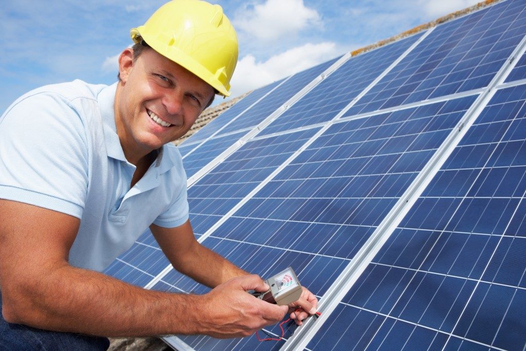 construction worker installing solar panel
