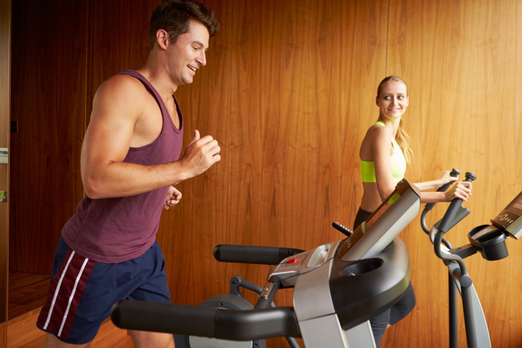 man and woman running on their treadmills