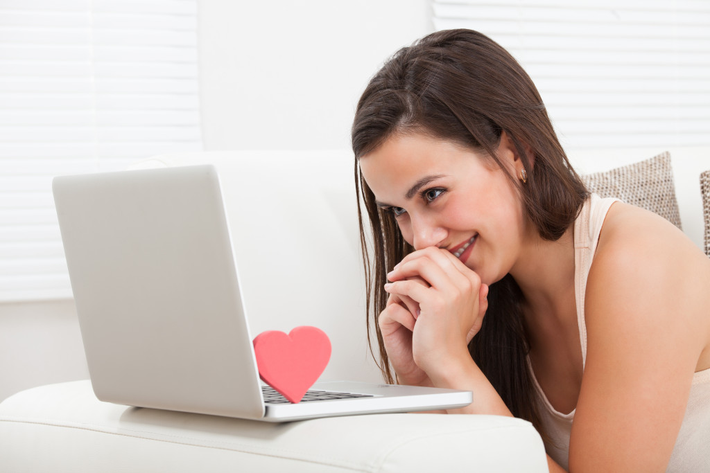 woman staring on her laptop with a heart on top of the keyboard